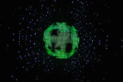 Defocused glowing green sphere surrounded by blue light particles Stock Illustration