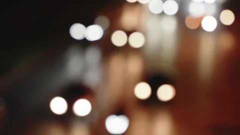 Defocused headlights of moving traffic at night on city road at rush hour. Stock Footage 309443354