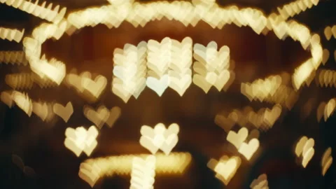 Defocused heart-shaped carousel lights, abstract bokeh effect with golden hearts Stock Footage 231924242