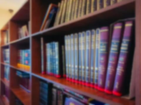 Defocused image. Multi-colored books on the bookshelf in the library Stock Photos