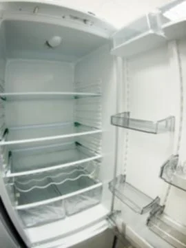 Defocused image of an open empty white refrigerator Stock Photos