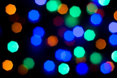Defocused light of multi-colored light bulbs at night Stock Photos