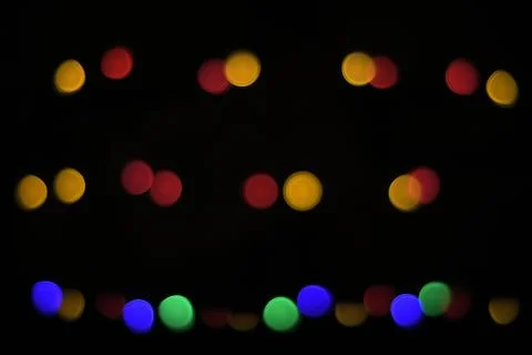 Defocused light of multi-colored light bulbs at night, bokeh Stock Photos
