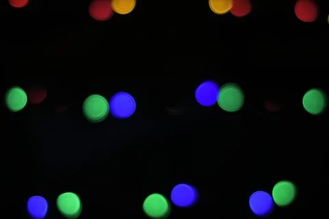Defocused light of multi-colored light bulbs at night, bokeh Stock Photos