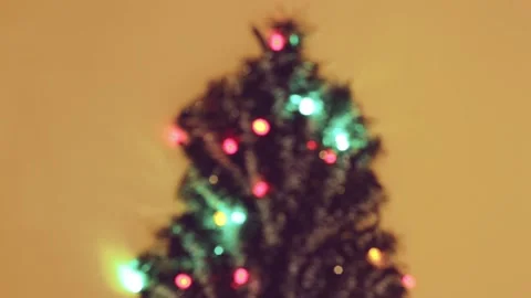 Defocused lights with different colors and christmas tree on yellow background Video stock 160921328