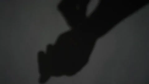 Defocused Long Shadow of Hands Intertwining and Directing Downwards Stock Footage 284925518