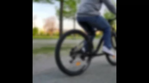 Defocused Low Angle Shot of Person Riding Bicycle in Park during Spring Stock Footage 322746272
