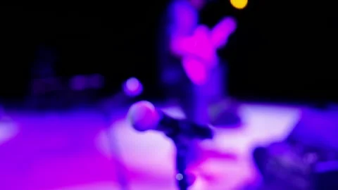 Defocused microphone on stage, rock man playing guitar, soft blur neon Stock-Footage 304028116