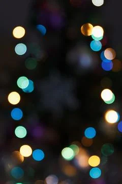 Defocused multicolored lights on dark background Stock Photos