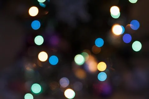Defocused multicolored lights on dark background Stock Photos