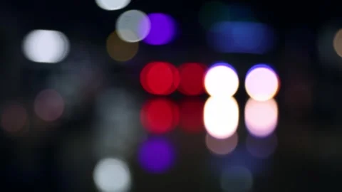 Defocused night traffic light on wet street after rain. Видео 337892851
