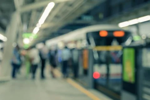 Defocused o f a queue of passengers at indoor train station Stock Photos