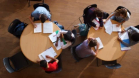 Defocused Overhead Shot Of High School Pupils In Group Study Around Table Stock Footage
