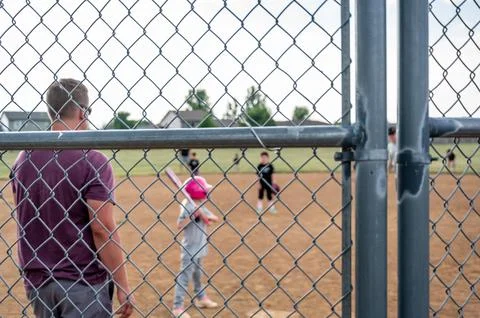 Defocused Parent view behind a chain link fence and home plate with a girl Foto stock