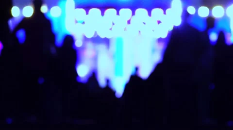 Defocused people silhouettes heading for night show. 4K background bokeh shot Stock Footage
