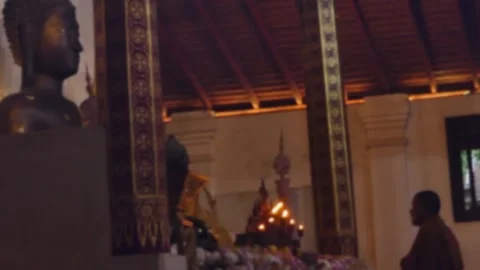 Defocused profile view of monk praying in lotus position at altar  Stock Footage 300882486