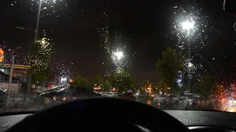 Defocused of rain drops on windshield and car wipers are removing rains.Driving  Stock Footage