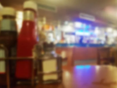 Defocused sauce bottles on a table inside a bar pub cafe Stock Photos