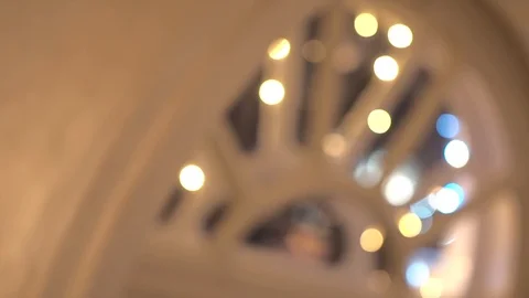 Defocused semi-circular window decorated with colorful garland at evening time Stock Footage 106237839