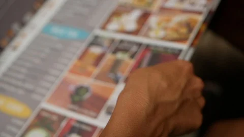 Defocused shot of choosing drinks from menu sitting in the bar sliding his Stock Footage 116244888