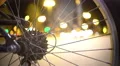 Defocused silhouettes of people walking city street, view through bicycle wheel 4k or 4k+ Resolution