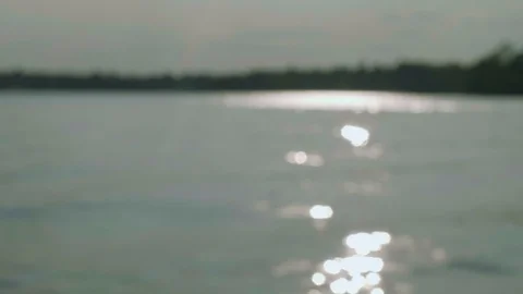 Defocused sparkles of sunlight on water surface during sunset Stock Footage 95675200