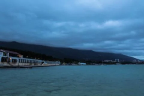 Defocused spring landscape. View from the pier to the sea, mountains in fog Photos