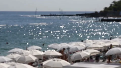 Defocused summer background with white parasols and blir beach seascape with sun Stock Footage 149269861