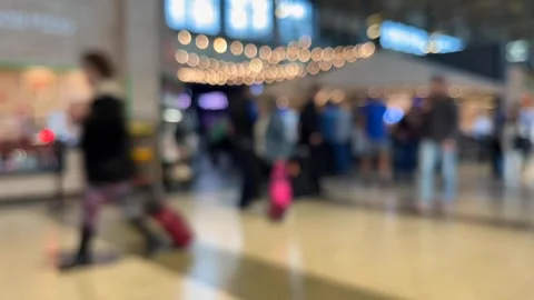 Defocused timelapse airline passengers pull luggage thru busy airport terminal Stock Footage 256248852