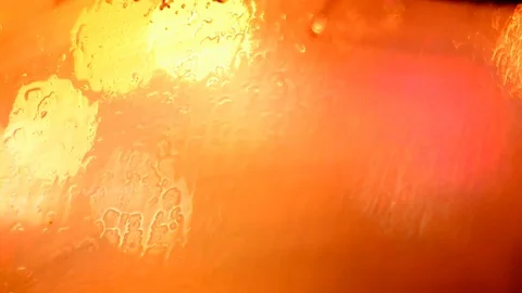 Defocused traffic lights through wet car glass. Stock Footage 73620213