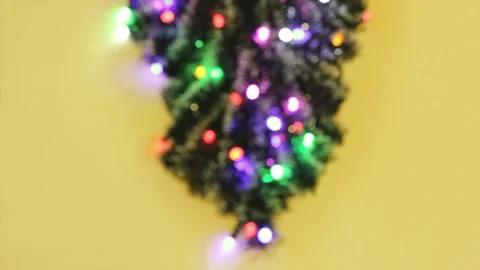 Defocused upside down christmas tree with different colors lights on yellow 스톡 동영상 206018810