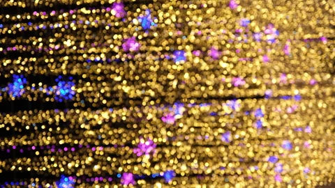 Defocused vertical LED garlands at night. Blurred glowing golden lights. 動画素材 247983418