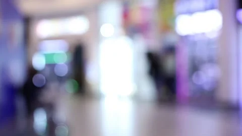 Defocused view of a brightly lit, inside of a shopping mall with neon lights Stock Footage 155298050