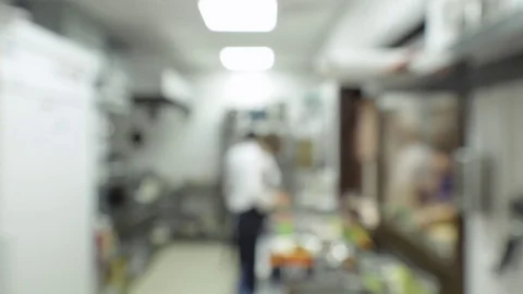 Defocused view. Professional cooks working in the kitchen of a restaurant cafe Stock Footage 74717848
