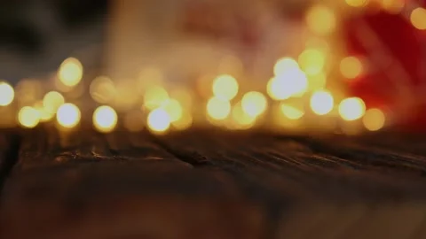 Defocused yellow blinking lights red Christmas garland wooden table background Stock Footage 164932432