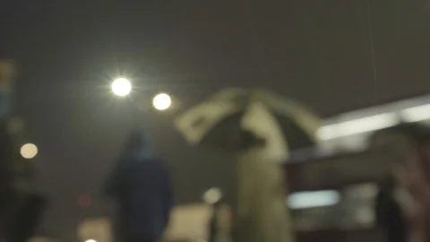 Defocussed commuters walking in the rain at night 스톡 동영상 118271985