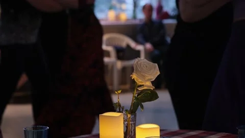 Defocussed people dancing tango in the background. focus on rose and candles. Stock Footage 199743402
