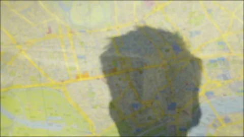 Defocussed shadow of a tourists head on a map POV Video stock 95288895