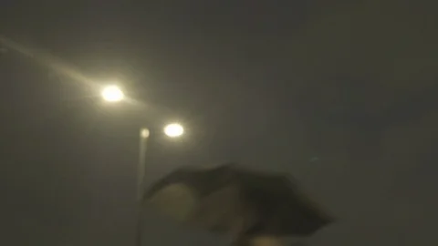 Defocussed view of commuters at night in the rain on london bridge Stock Footage 96476312