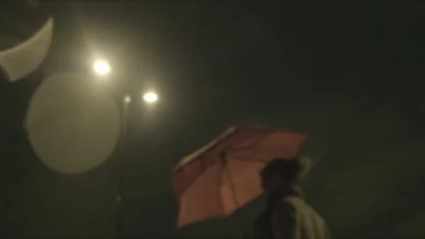 Defocussed view of commuters at night in the rain on london bridge Stock Footage 96518201