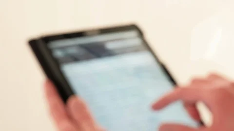 Defocussed view of a man using a tablet computer against a plain background Video stock 87000487