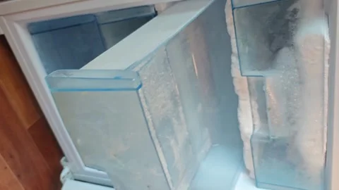 Defrosting the freezer in a home kitchen during a morning routine Stock Footage 340461708