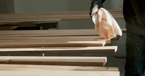 Deftly De-dusting- A Carpenter Clears Sawdust from Sanded Wood Boards Durin.. Stock Footage 237276550