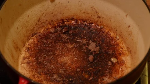 Deglazing the bottom of a casserole dish using beer Stock Footage 121449223