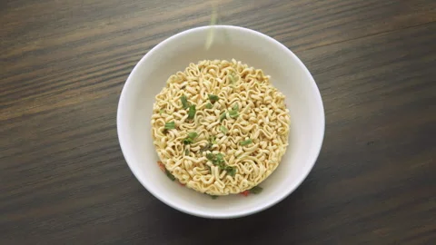 Dehydrated vegetables are spilling onto dried instant noodles Stock Footage 322875803