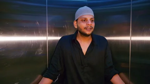 Dejected muslim guy holds back tears in moving lift Stock Footage 310285028