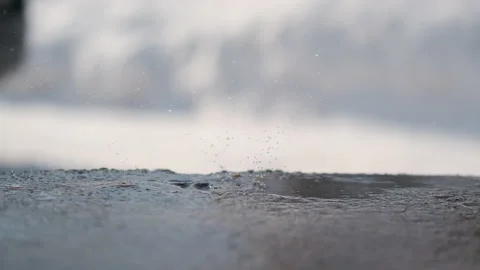 Delayed raindrop falling on cement. The snow is melting Stock Footage 149784964