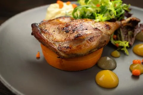 Delectable pan-seared duck leg with healthy vegetable medley Stock Photos