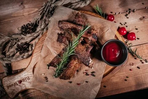 A delectable presentation of grilled ribs arranged on parchment paper with ar Stock Photos