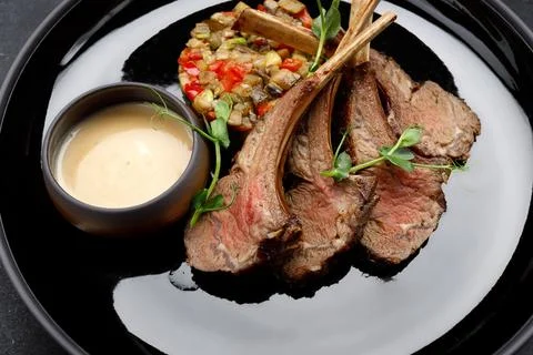 Delectable ribs with grilled vegetable salad and savory sauce Stock Photos